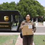 A woman standing in front of a ups delivery truck.